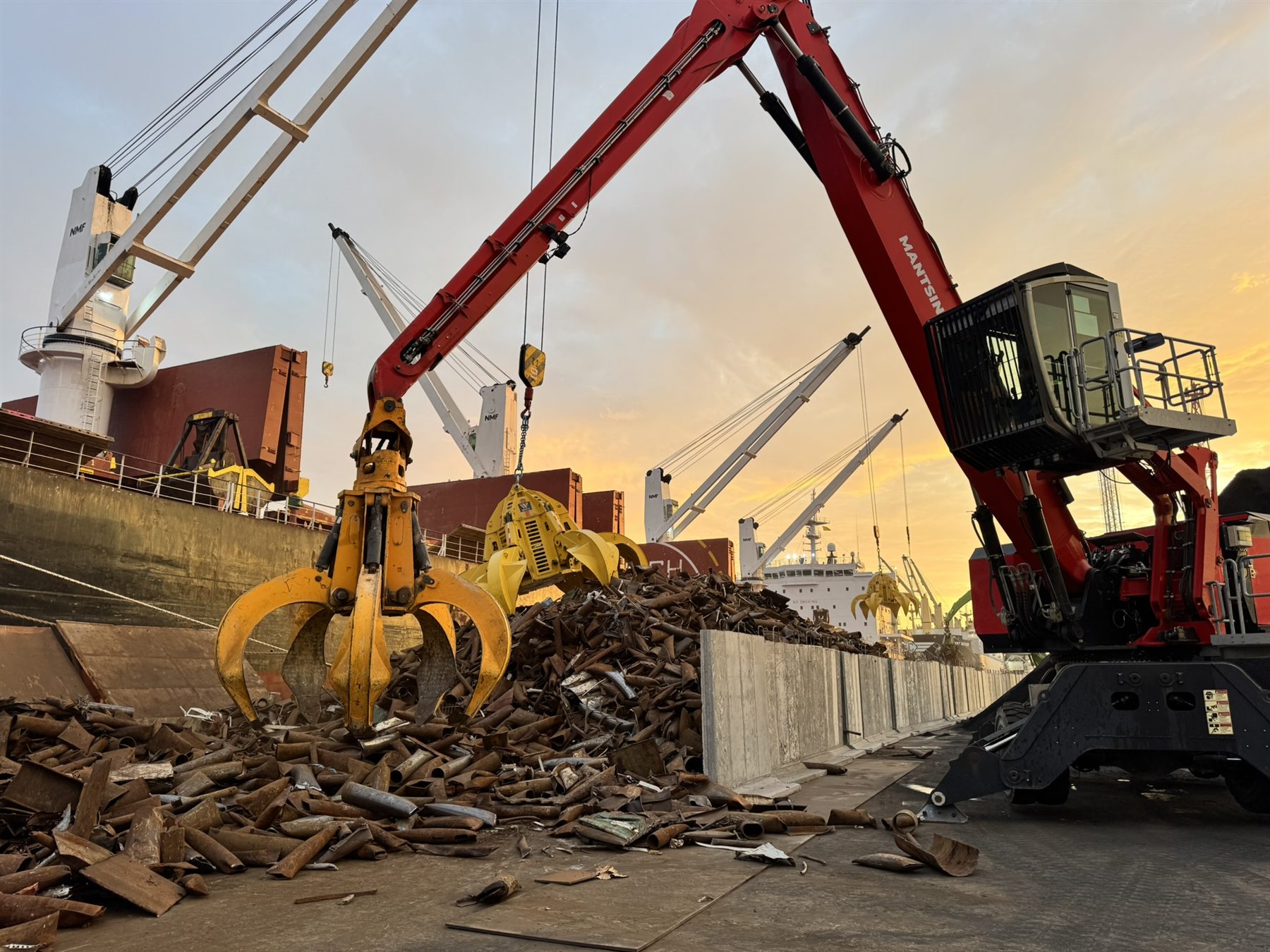 Material handler loading a bulk vessel at sunset