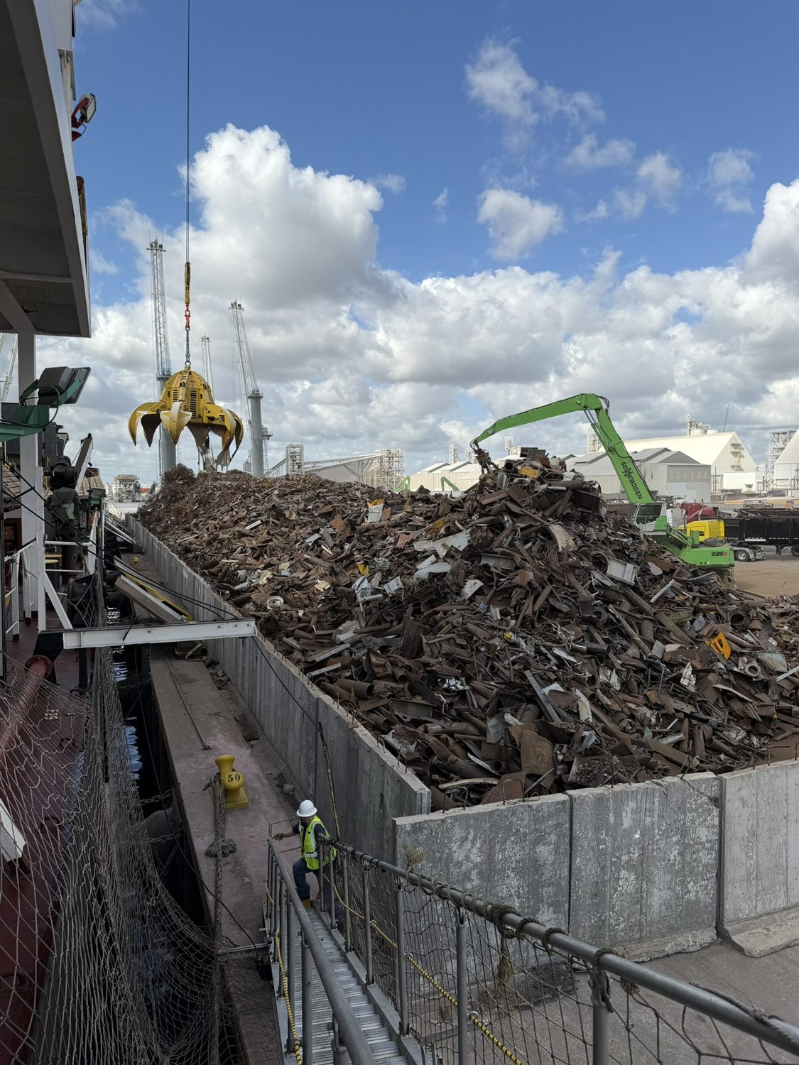 Grapple loading a bulk vessel hold with ferrous scrap for export