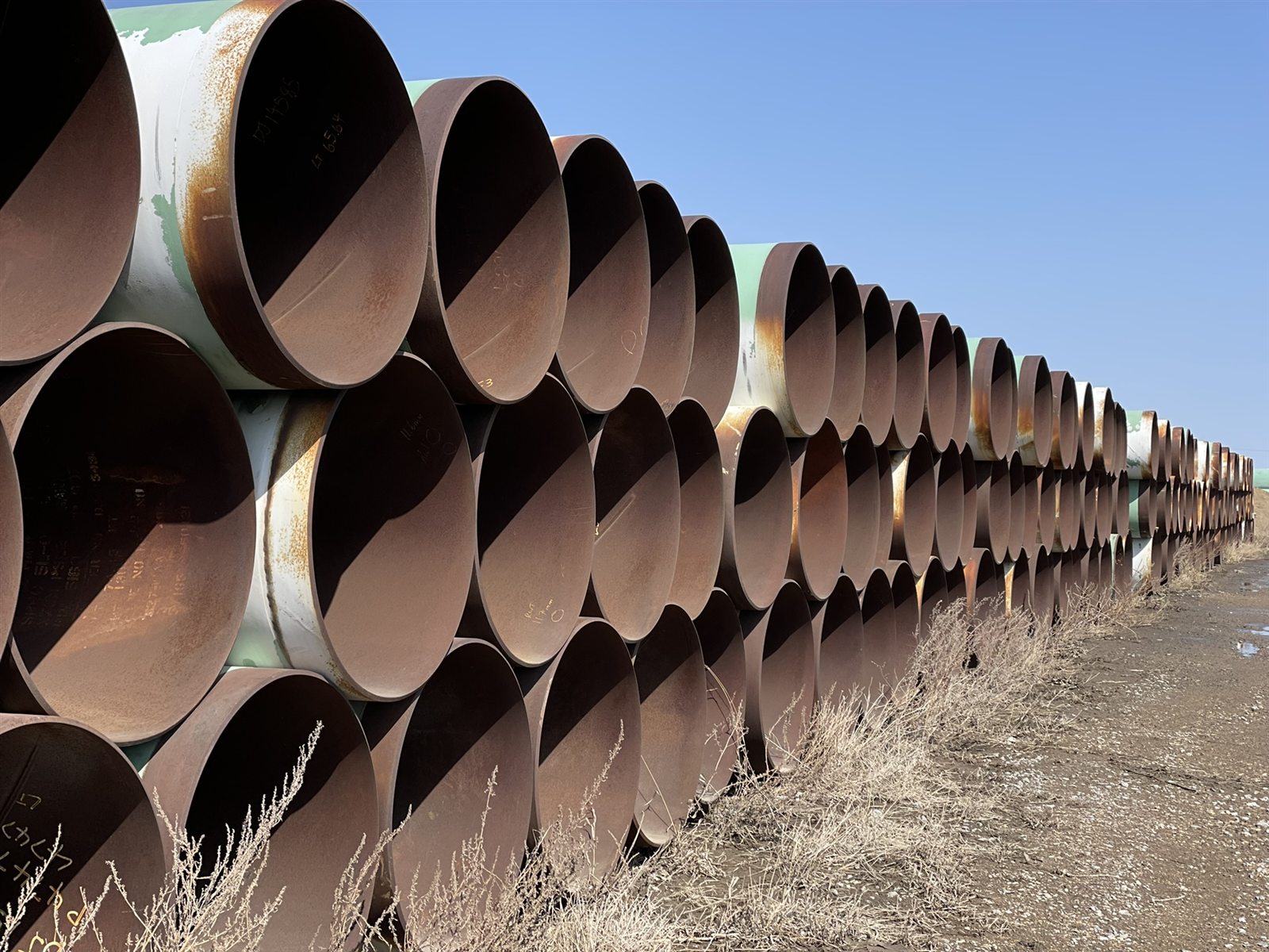 Stacks of coated surplus line pipe