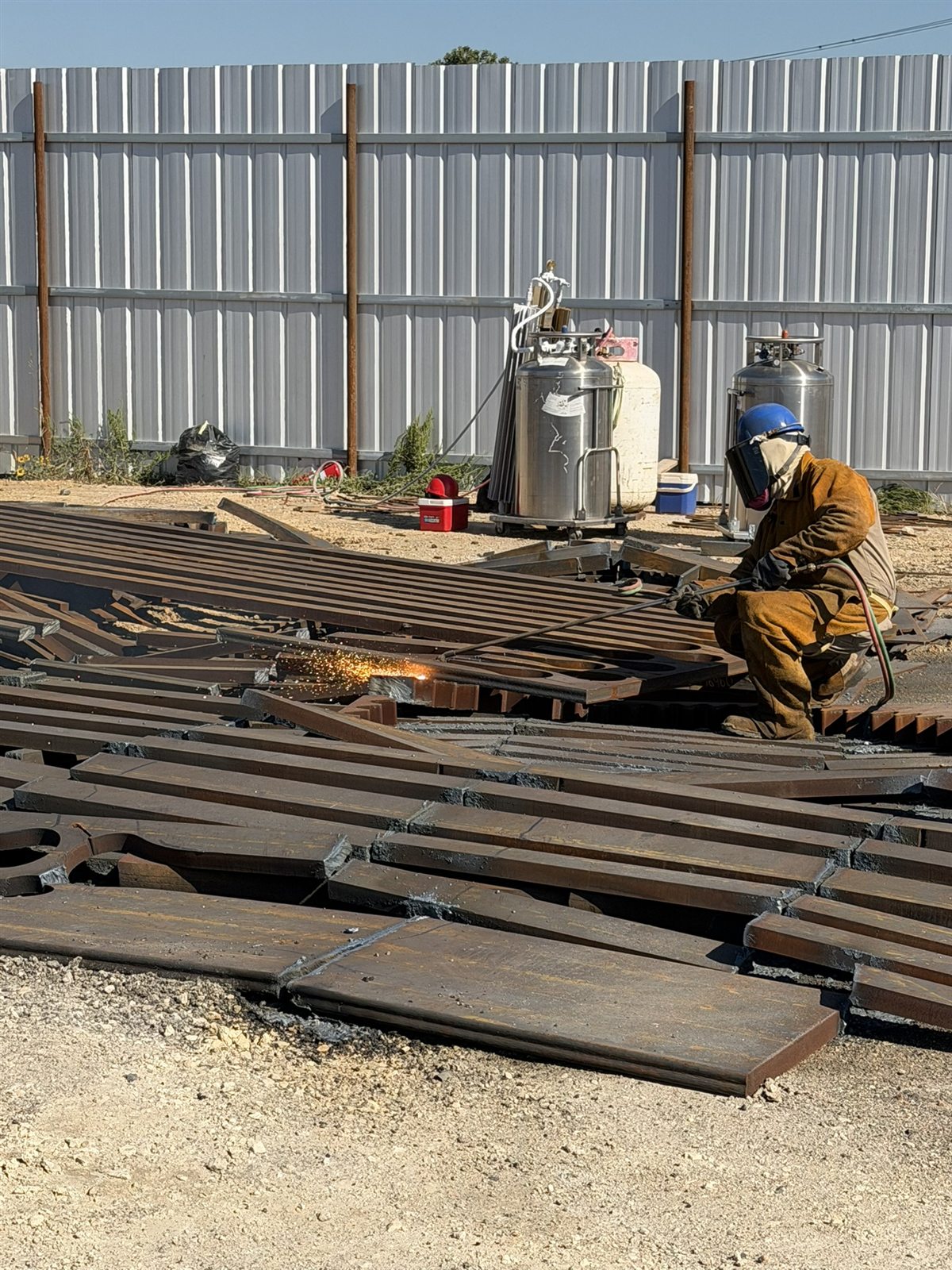 Gold Star Metals crew torch-cutting steel safely on site in full protective gear
